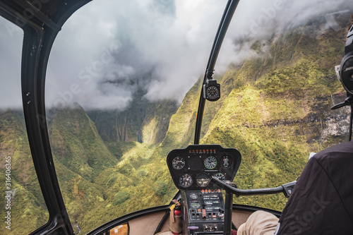 Aerial view from helicopter cockpit of Kauai's lush colorful interior mountain landscape. 