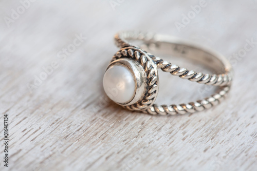 Silver ring on neutral bright wooden background