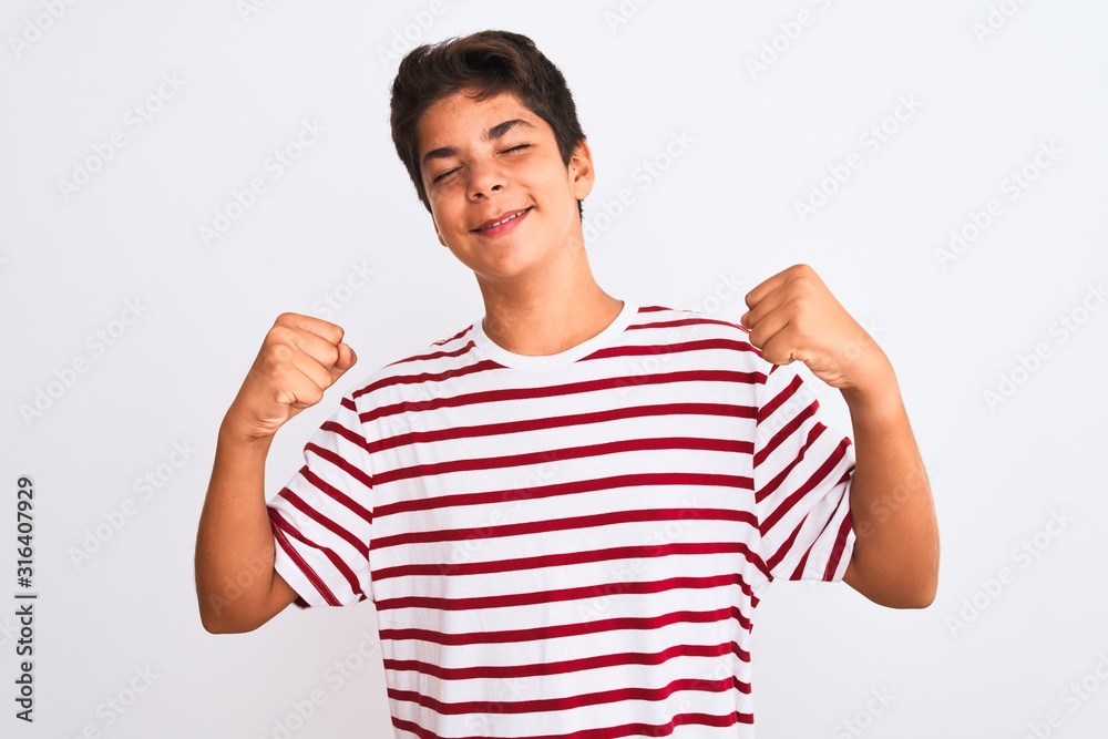 Handsome teenager boy standing over white isolated background very happy and excited doing winner gesture with arms raised, smiling and screaming for success. Celebration concept. Handsome teenager boy standing over white isolated background very happy and excited doing winner gesture with arms raised, smiling and screaming for success. Celebration concept.