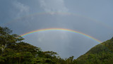 a double rainbow shot at a summer day in Baños, Ecuador