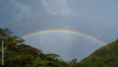 Fototapeta Naklejka Na Ścianę i Meble -  a double rainbow shot at a summer day in Baños, Ecuador