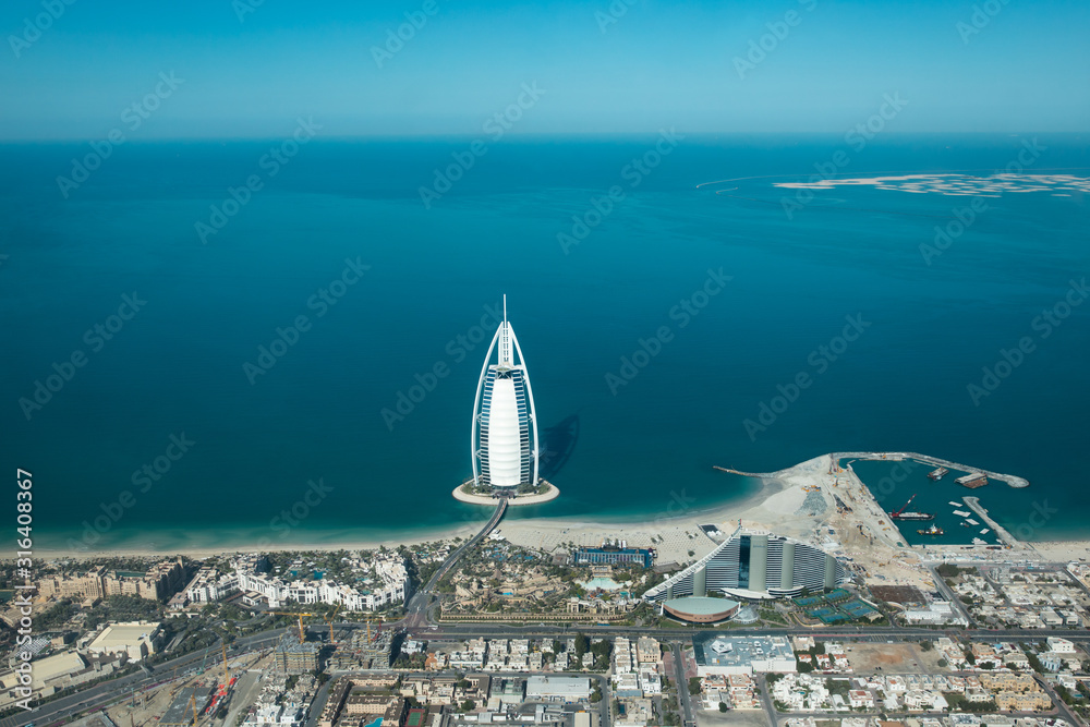 Fototapeta Widok z lotu ptaka z pejzażu dzielnicy Dubai Jumeirah i wysp świata w słoneczny dzień. Dubaj, Zjednoczone Emiraty Arabskie.