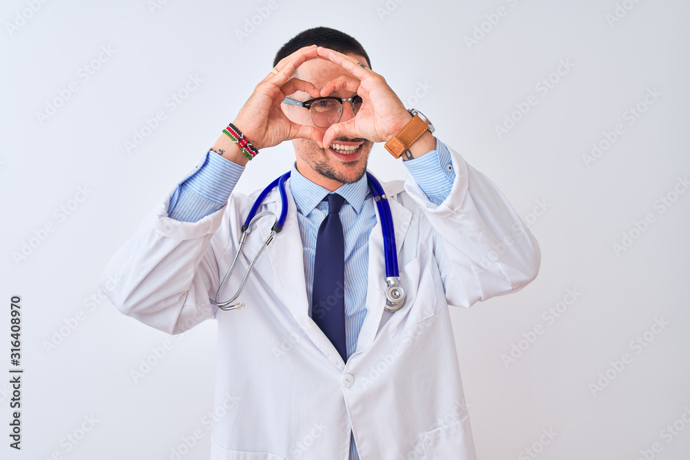 Young doctor man wearing stethoscope over isolated background Doing heart shape with hand and fingers smiling looking through sign Young doctor man wearing stethoscope over isolated background Doing heart shape with hand and fingers smiling looking through sign