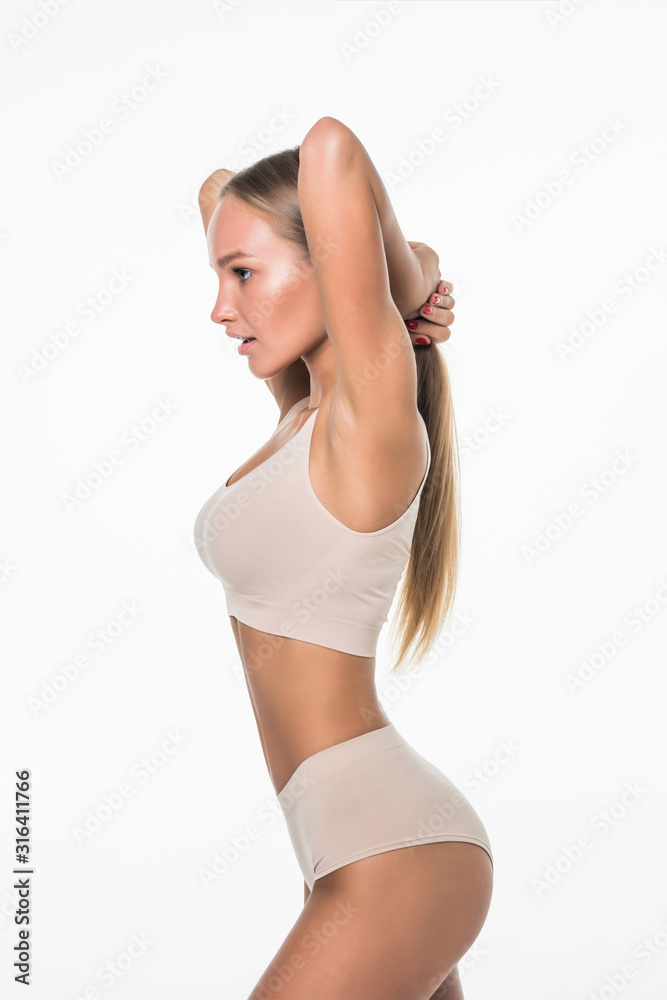 Slim tanned woman in beige underwear isolated over white background. Healthy lifestyles concept. Slim tanned woman in beige underwear isolated over white background. Healthy lifestyles concept.