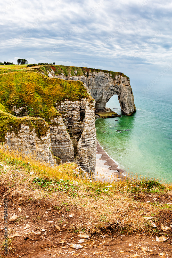 View of natural chalk cliffs of Etretat with visible arche and beach coastline, Normandy, France, Europe