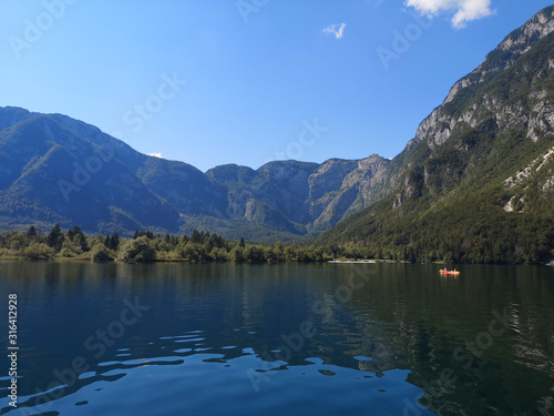 Beautiful view of the crystal clear Bohinj lake from the water with the mountains in the background