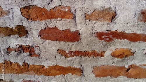 Old roman brick. The restored wall of the building of the Roman conquerors. Warm brown-red shades of uneven bricks. Archaeological site in the city of Sremska Mitrovica, Serbia. photo