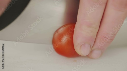 Closeup cook man slicing fresh tomatoes photo