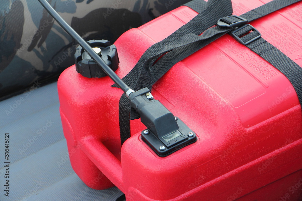 Fototapeta premium Red plastic boat fuel tank in cockpit inflatable boat, water activity safety