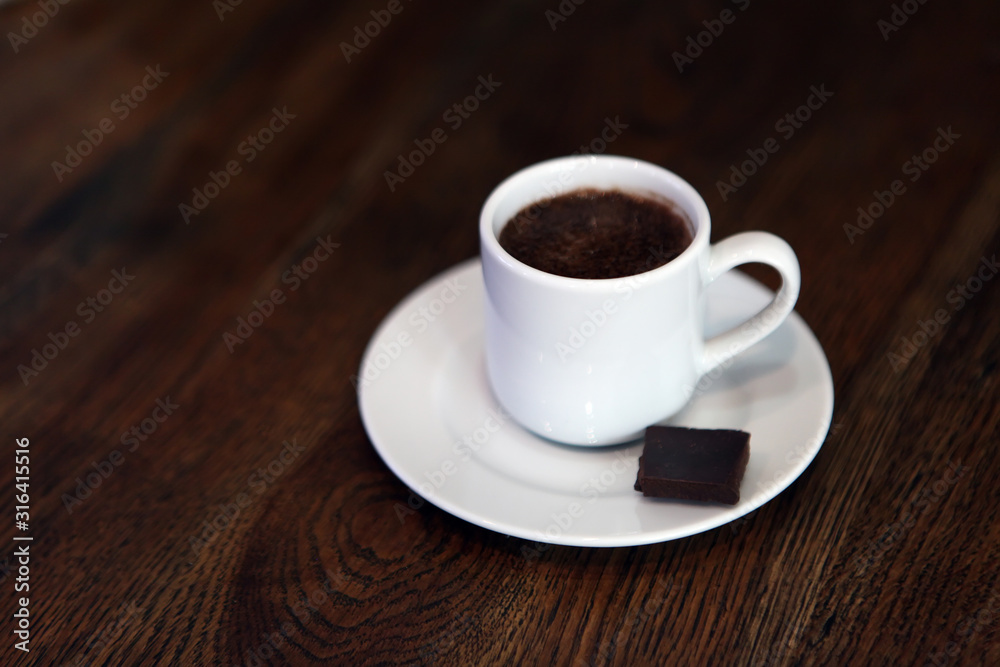 cup of hot coffee on a dark background. Hot Chocolate in a white ceramic mug. teacup with hot chocolate. tasty drink on porcelain mug. A Cup of festive hot chocolate.