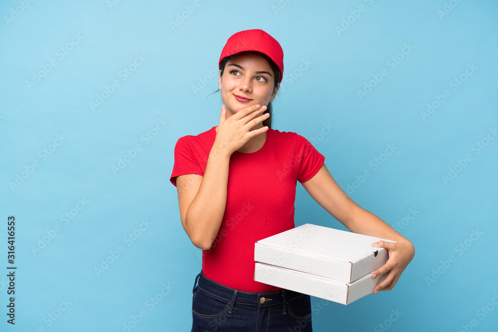 Young woman holding a pizza over isolated pink wall thinking an idea Young woman holding a pizza over isolated pink wall thinking an idea