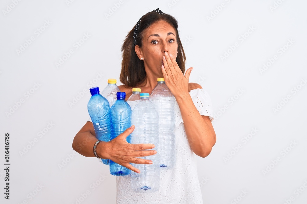 Middle age beautiful woman recycling plastic bottles standing over isolated white background cover mouth with hand shocked with shame for mistake, expression of fear, scared in silence, secret concept Middle age beautiful woman recycling plastic bottles standing over isolated white background cover mouth with hand shocked with shame for mistake, expression of fear, scared in silence, secret concept