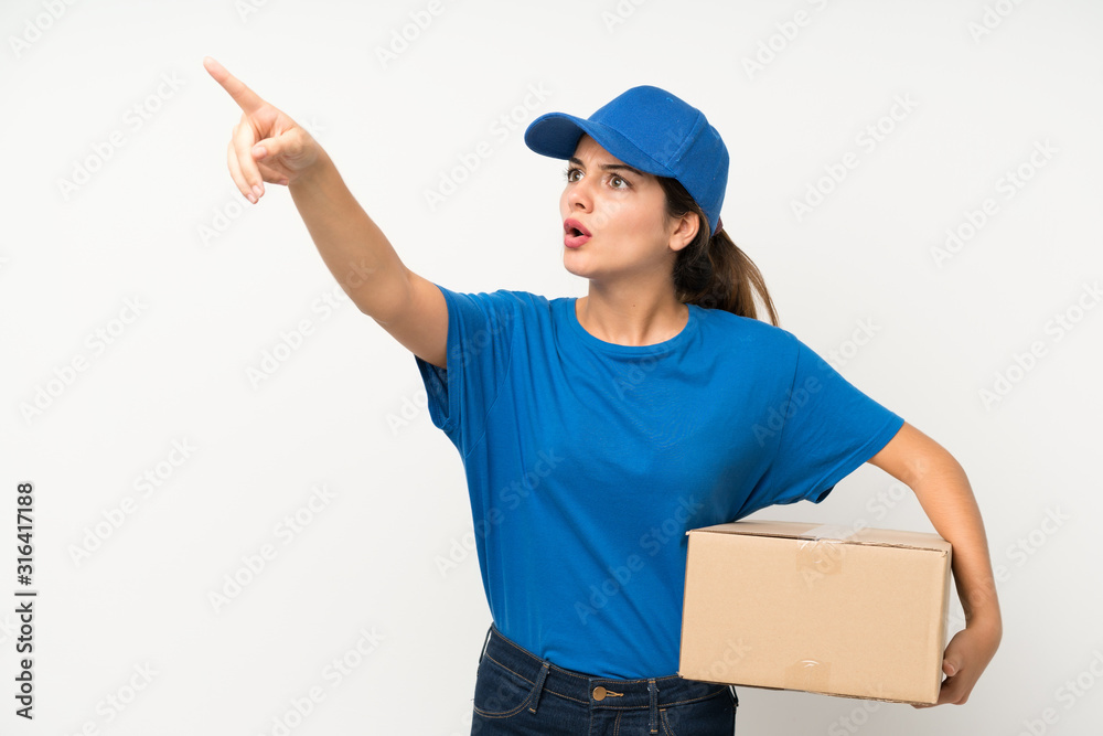 Young delivery girl over isolated white background pointing away Young delivery girl over isolated white background pointing away