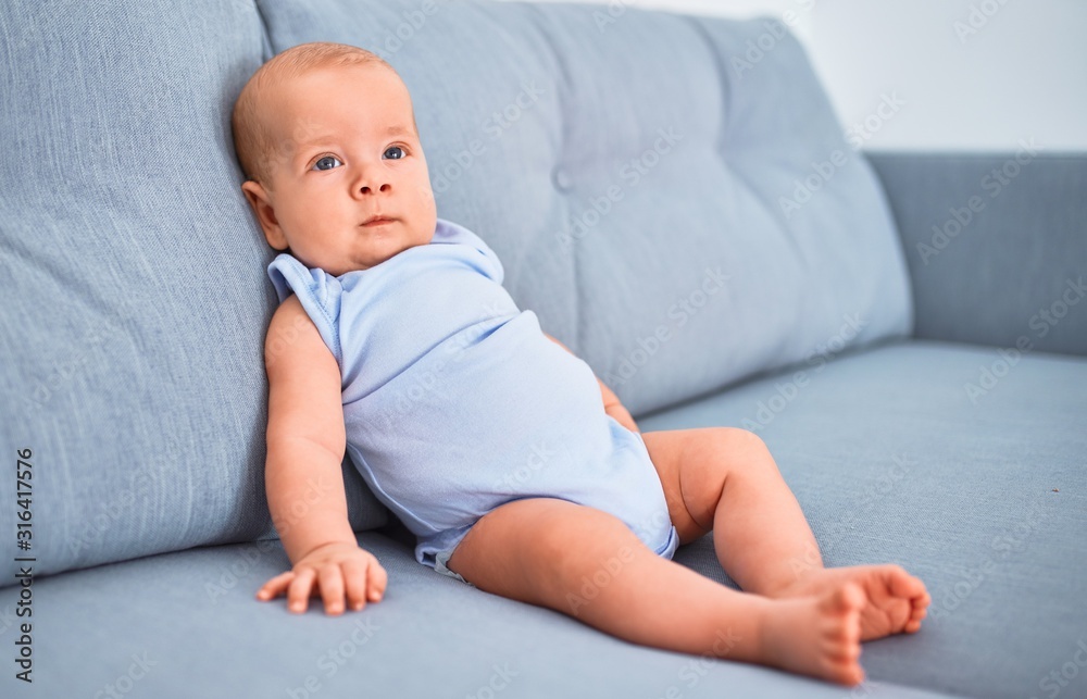 Adorable baby lying down on the sofa at home. Newborn relaxing and resting comfortable Adorable baby lying down on the sofa at home. Newborn relaxing and resting comfortable