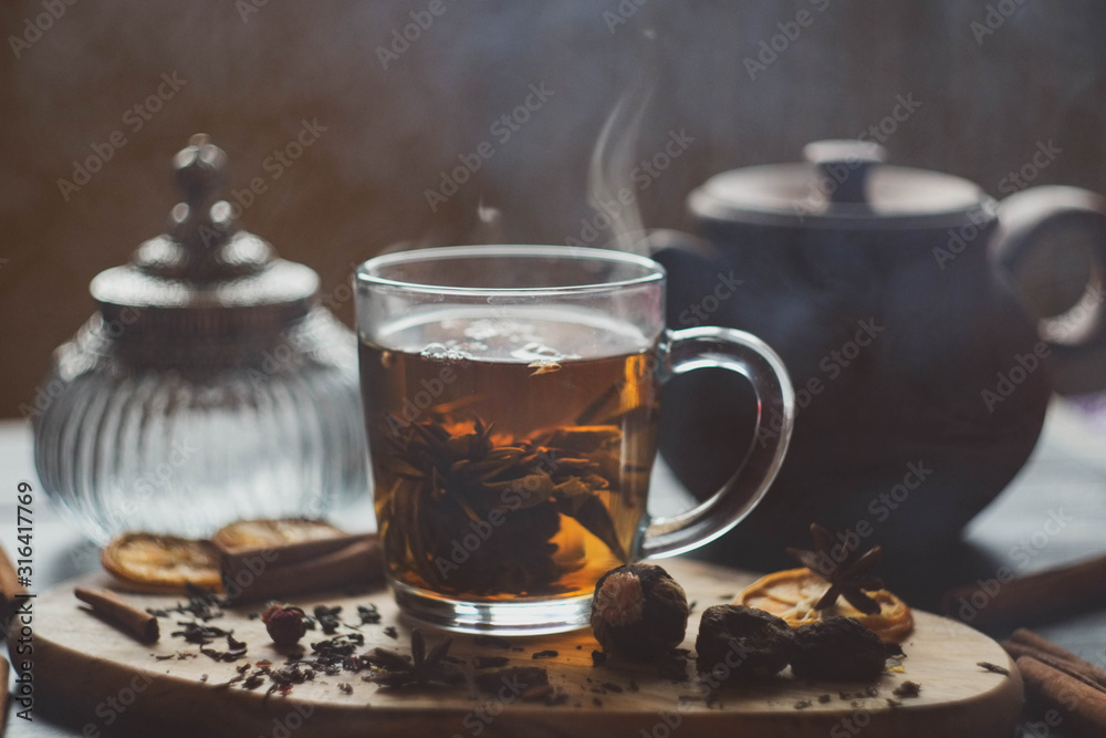 flower tea in a transparent mug with welding and spices/ vintage bottle and clay teapot flower tea in a transparent mug with welding and spices/ vintage bottle and clay teapot