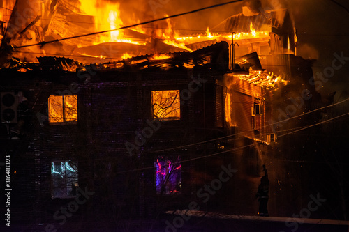 firefighters extinguish burning house in the dark  Burning building in Samara  Russia