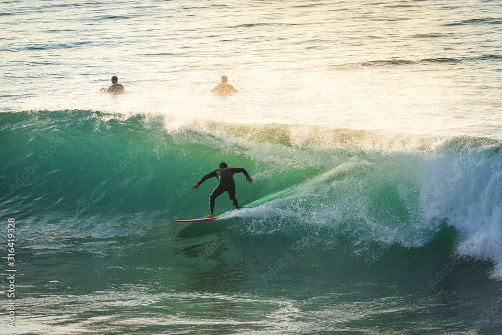 Surfer on Ocean Wave Getting Barreled at Sunset