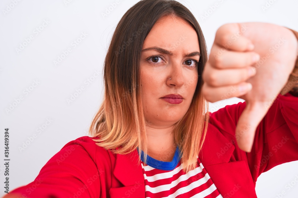 Beautiful woman wearing striped t-shirt and jacket standing over isolated white background with angry face, negative sign showing dislike with thumbs down, rejection concept Beautiful woman wearing striped t-shirt and jacket standing over isolated white background with angry face, negative sign showing dislike with thumbs down, rejection concept