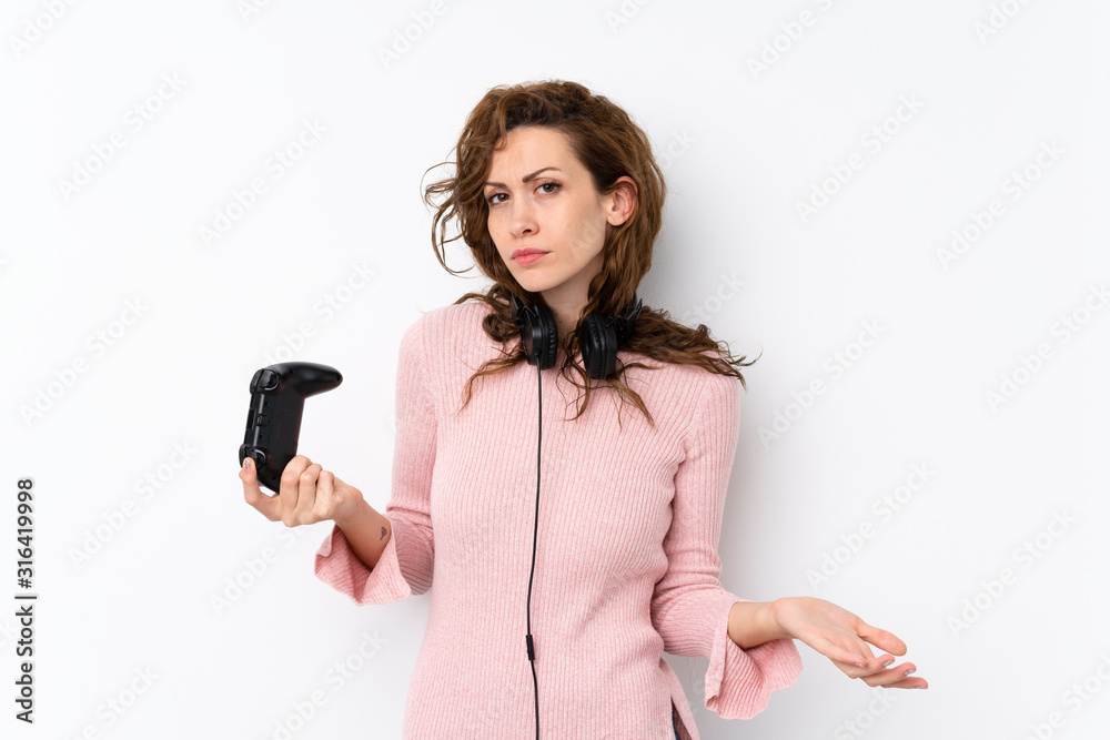 Naklejka premium Young pretty woman over isolated background playing at videogames