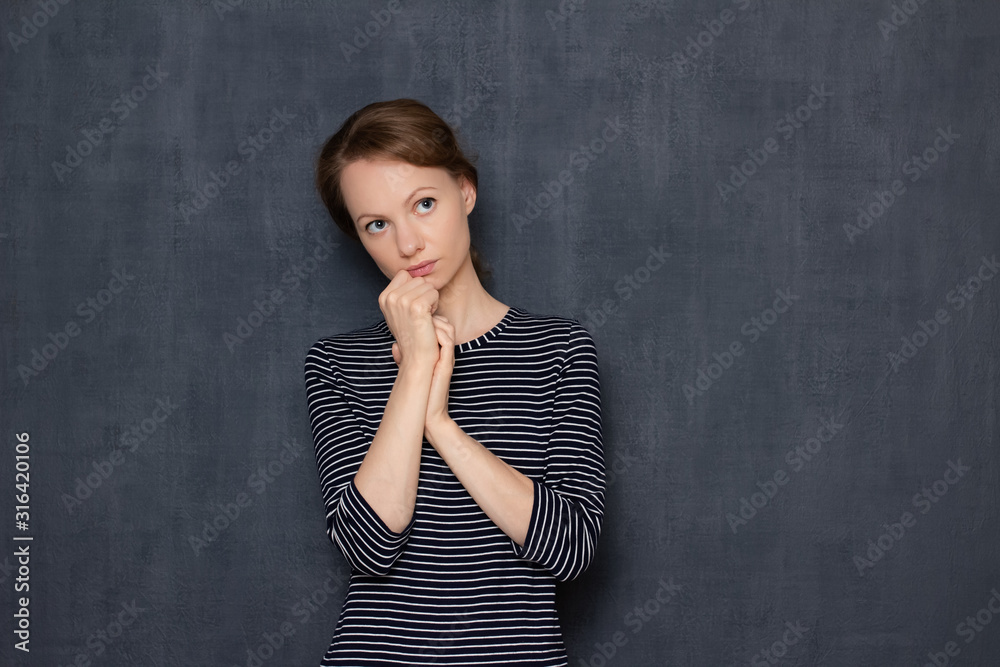 Portrait of focused pensive young woman being deep in thoughts