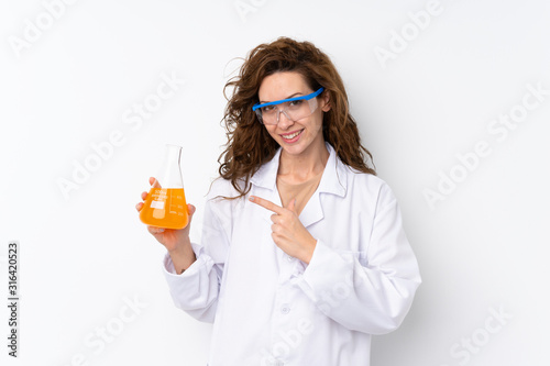 Young pretty woman over isolated background with a scientific test tube and pointing it