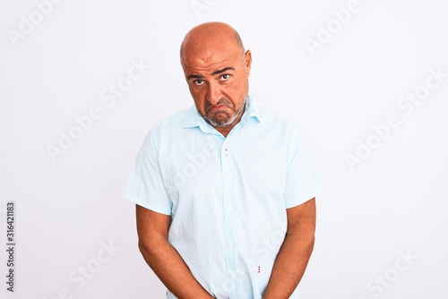 Middle age handsome man wearing casual shirt standing over isolated white background depressed and worry for distress, crying angry and afraid. Sad expression.