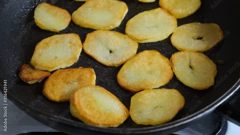 sliced potatoes fried in a pan in sunflower oil sliced potatoes fried in a pan in sunflower oil