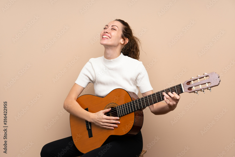Young woman with guitar over isolated background Young woman with guitar over isolated background