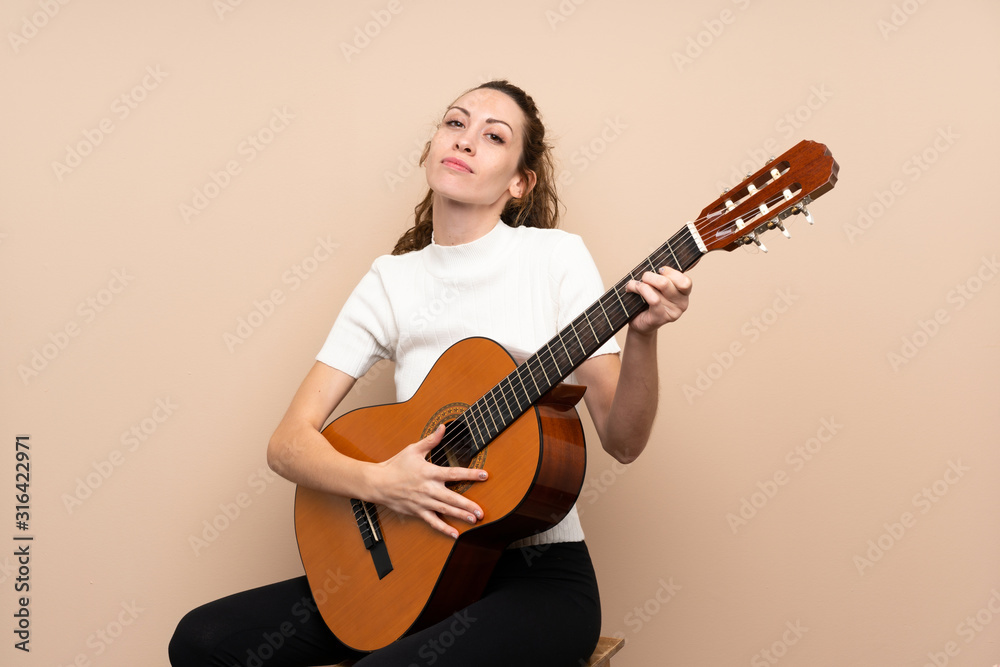 Young woman with guitar over isolated background Young woman with guitar over isolated background
