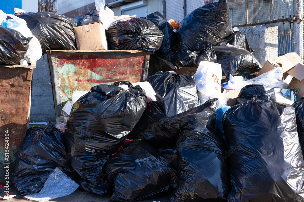 Crowded trash bins, trash in the street. Crowded trash bins, trash in the street.