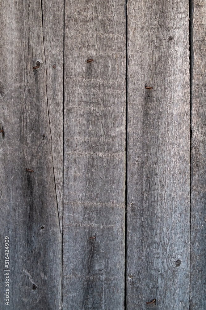 The texture of the old wooden board. Vertical layout. Old rusty nails are visible from the boards The texture of the old wooden board. Vertical layout. Old rusty nails are visible from the boards