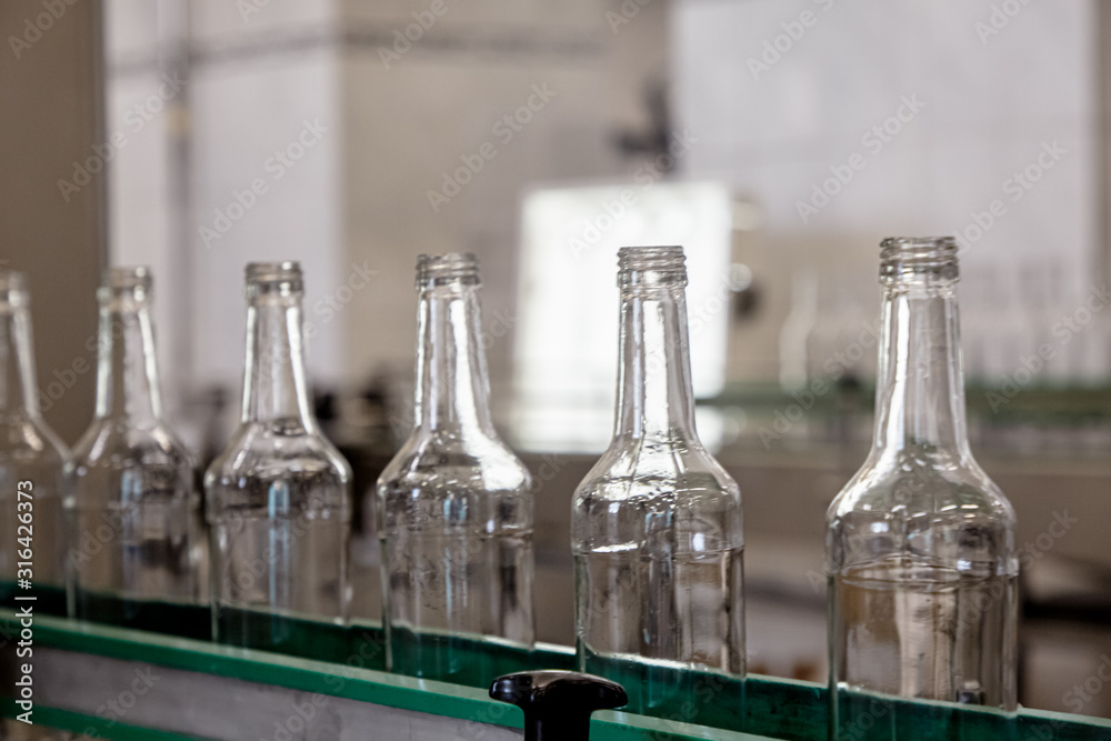 Bottles are moving on a conveyor belt at a factory for the production of Russian vodka