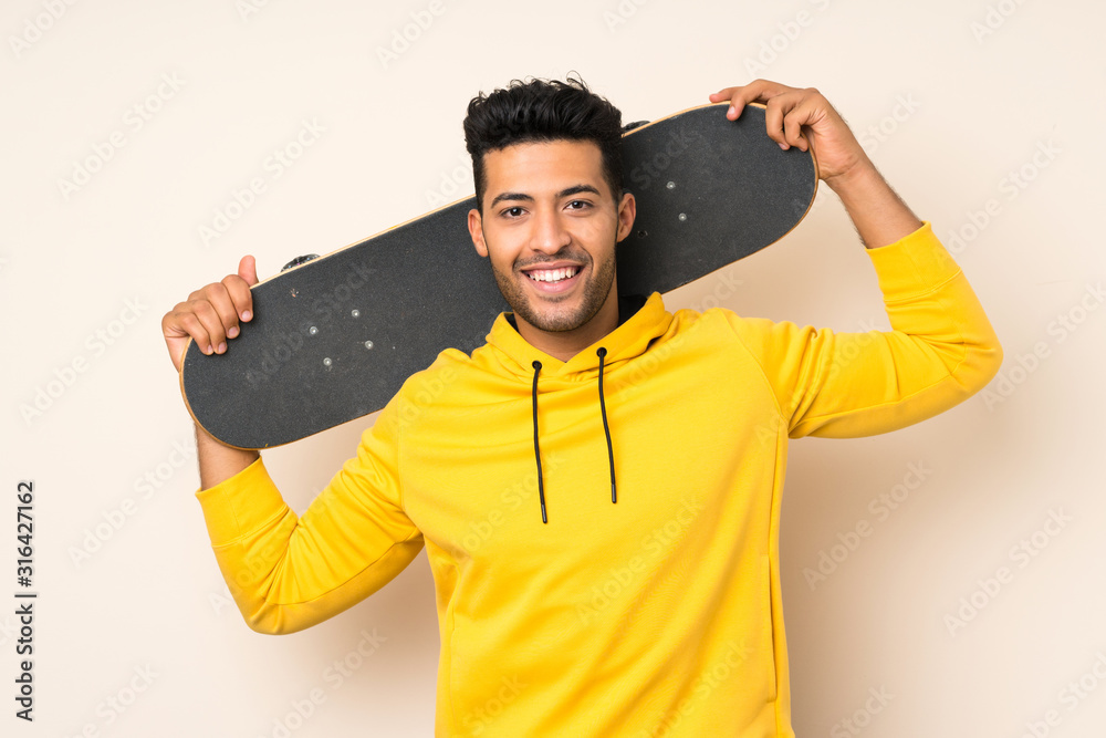 Young handsome man over isolated background with skate Young handsome man over isolated background with skate