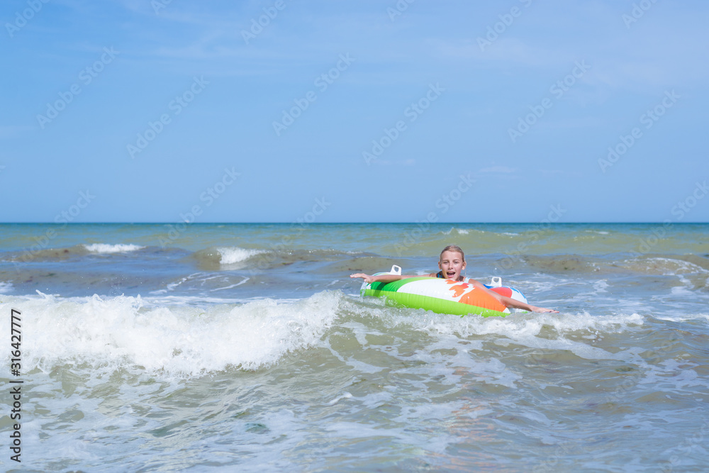 Sea with waves and a girl in the inflatable circle in the distance. Sea with waves and a girl in the inflatable circle in the distance.