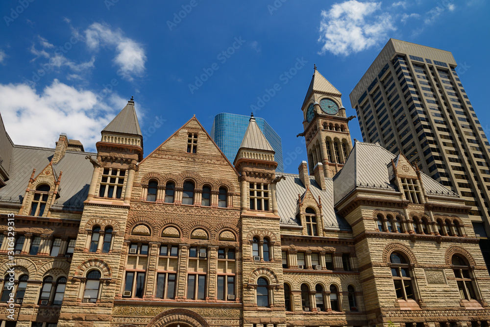 Refurbished stonework of the old 1889 Toronto City Hall with highrise buildings