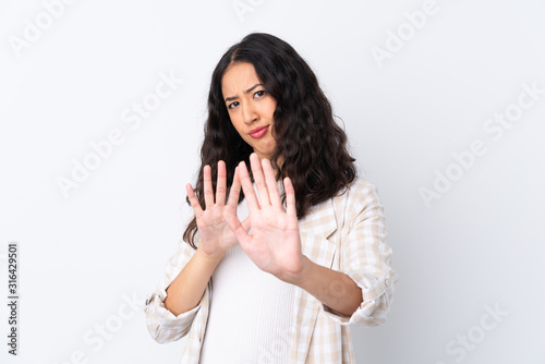 Mixed race woman over isolated white background nervous stretching hands to the front