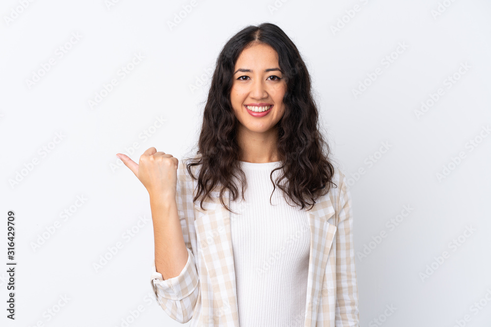 Mixed race woman over isolated white background pointing to the side to present a product Mixed race woman over isolated white background pointing to the side to present a product