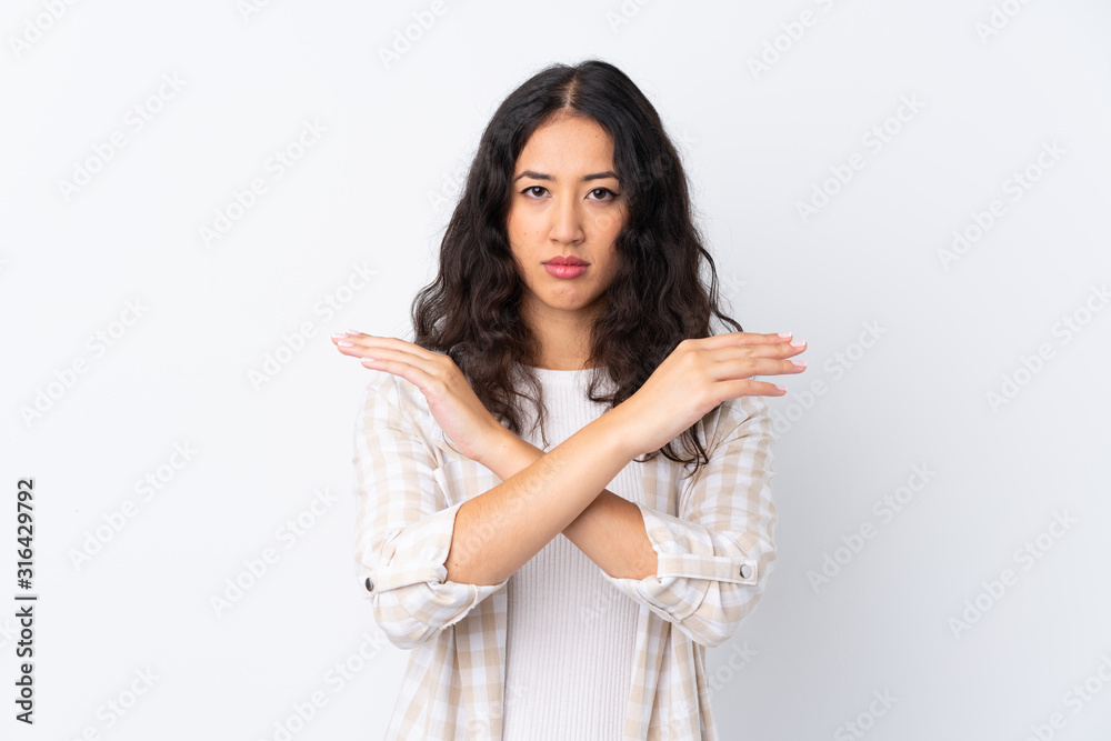 Mixed race woman over isolated white background making NO gesture Mixed race woman over isolated white background making NO gesture