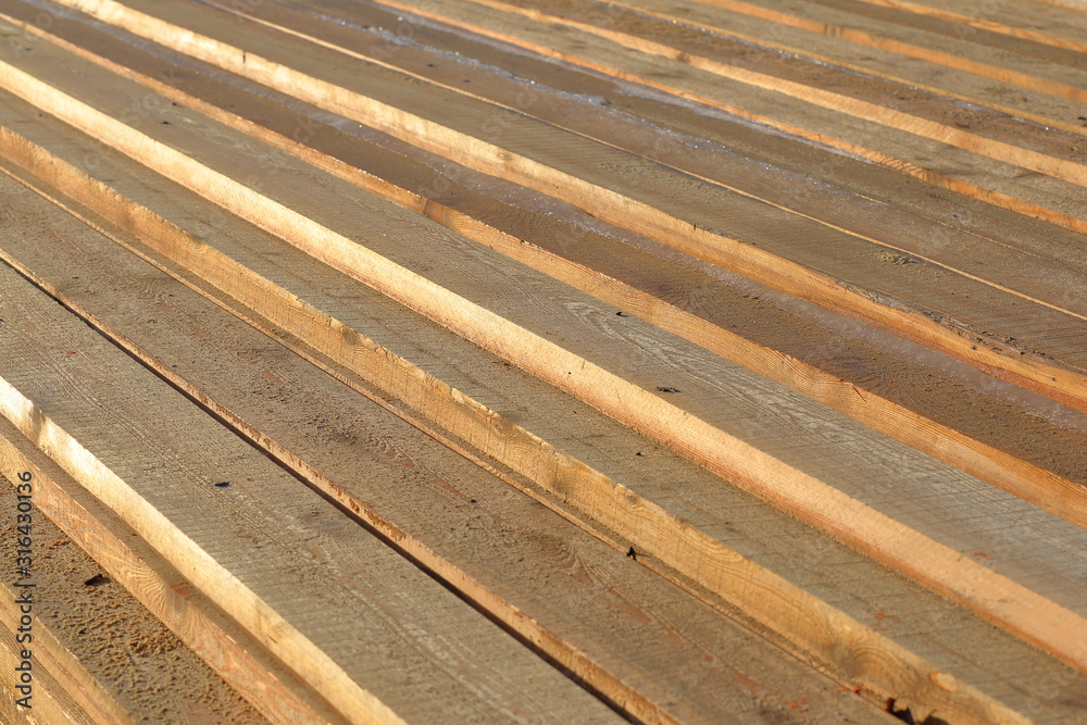 Heap of long wooden boards for the construction and improvement of the yard