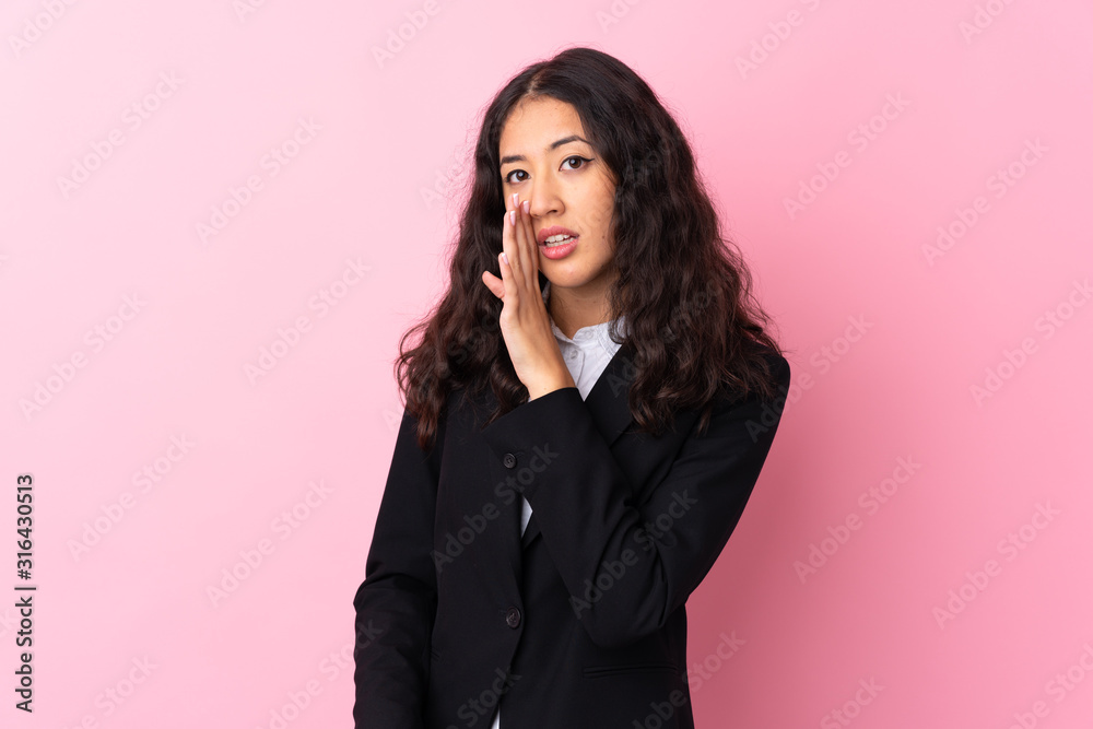 Mixed race business woman over isolated pink background whispering something Mixed race business woman over isolated pink background whispering something