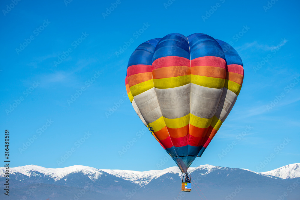 Fototapeta premium Hot air baloon in the mountain winter