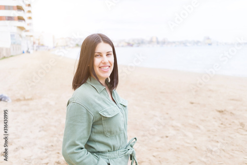 Young beautiful woman smiling very happy by the beach