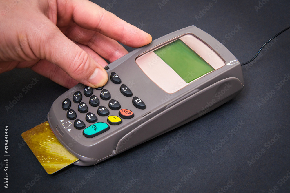 Hand entering pin code to money terminal before payment Hand entering pin code to money terminal before payment
