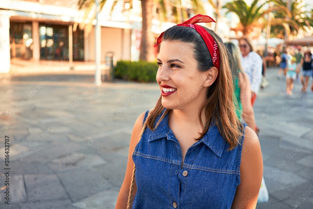 Fototapeta premium Young beautiful woman smiling happy walking on city streets of Puerto de la Cruz, Tenerife on a sunny day of summer