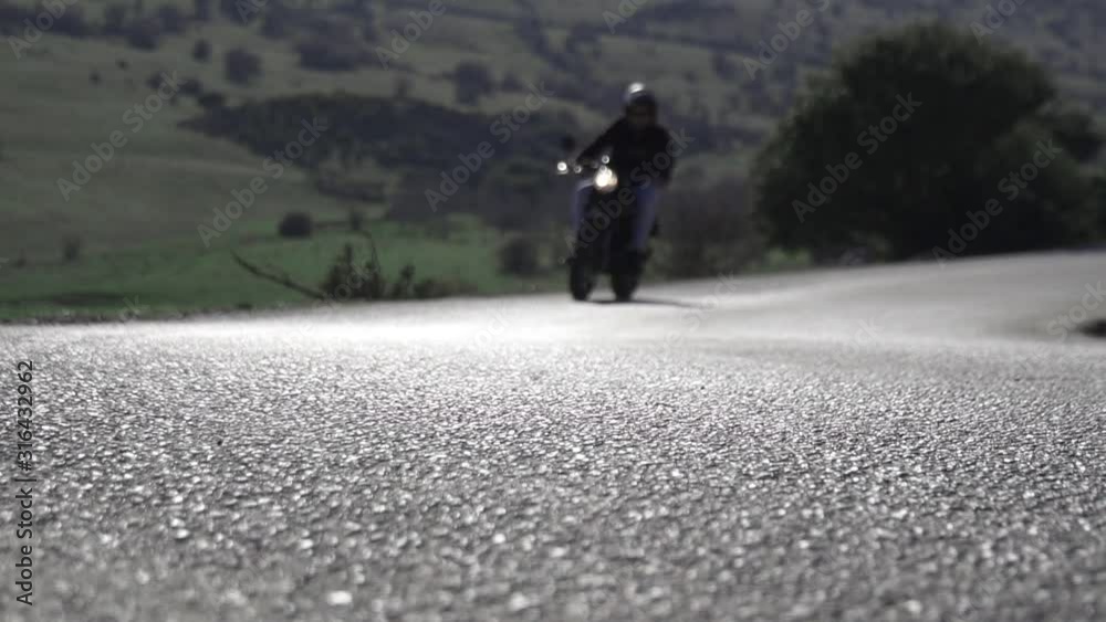 Motorista conduciendo motocicleta en una curva entre montañas y naturaleza HD
