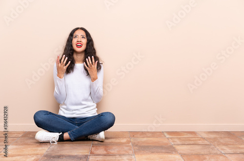 Young woman sitting on the floor frustrated by a bad situation