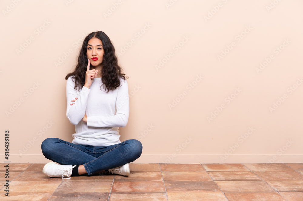 Young woman sitting on the floor Looking front Young woman sitting on the floor Looking front