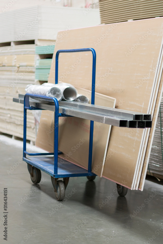 Trolley in a hardware store loaded with construction materials. Repair and construction concept. vertical photo Trolley in a hardware store loaded with construction materials. Repair and construction concept. vertical photo