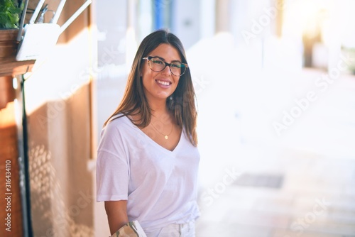 Young beautiful woman smiling happy and confident. Standing with smile on face at the town street