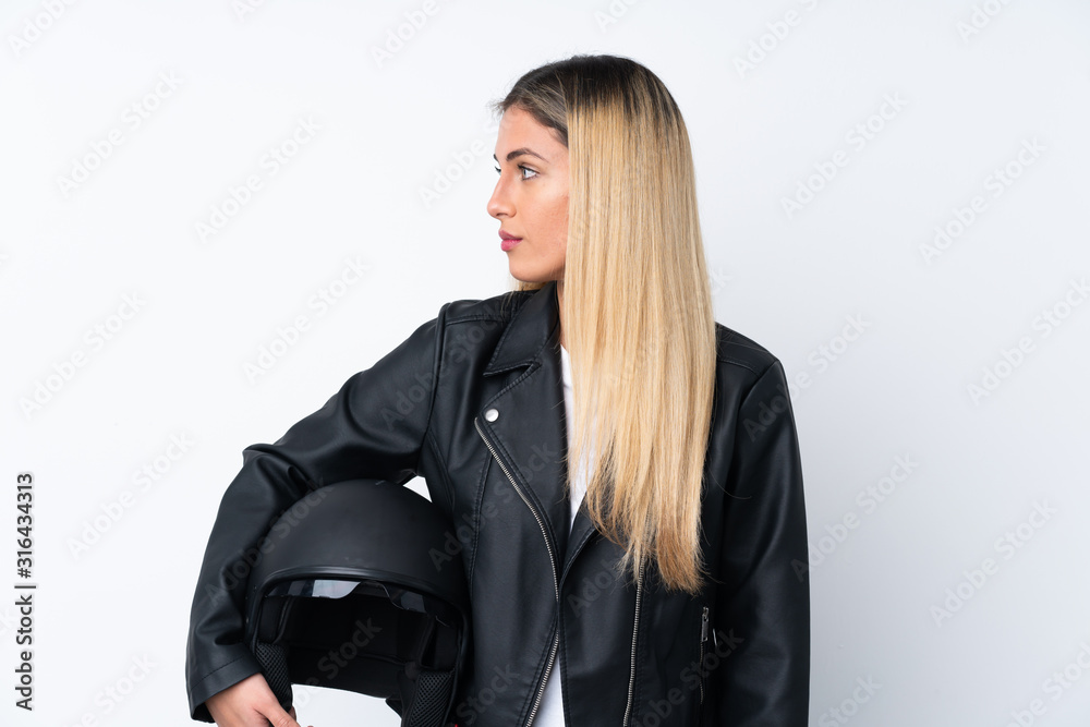 Young Uruguayan woman with a motorcycle helmet over isolated white  background looking side Stock Photo | Adobe Stock
